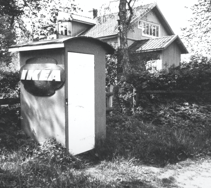 A freestanding small shed with the IKEA logo is near a house.